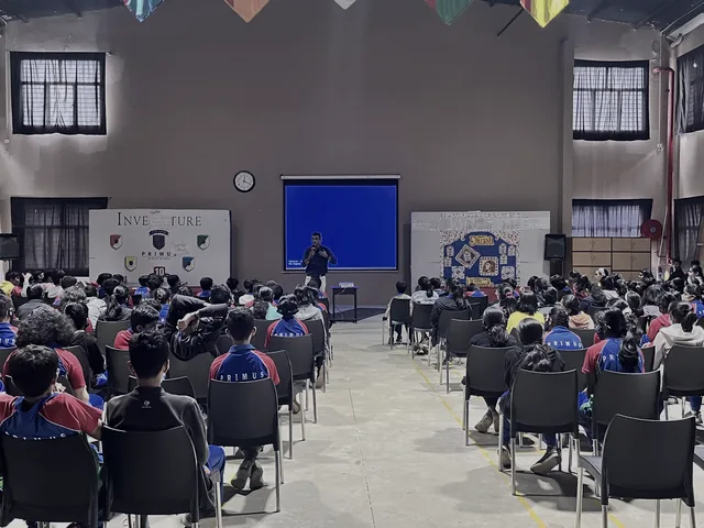 Students seated in a school hall facing a presentation